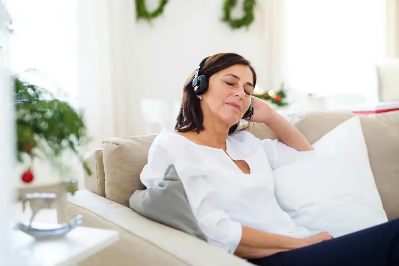 Woman mediating with smartphone app on coach around holiday decorations